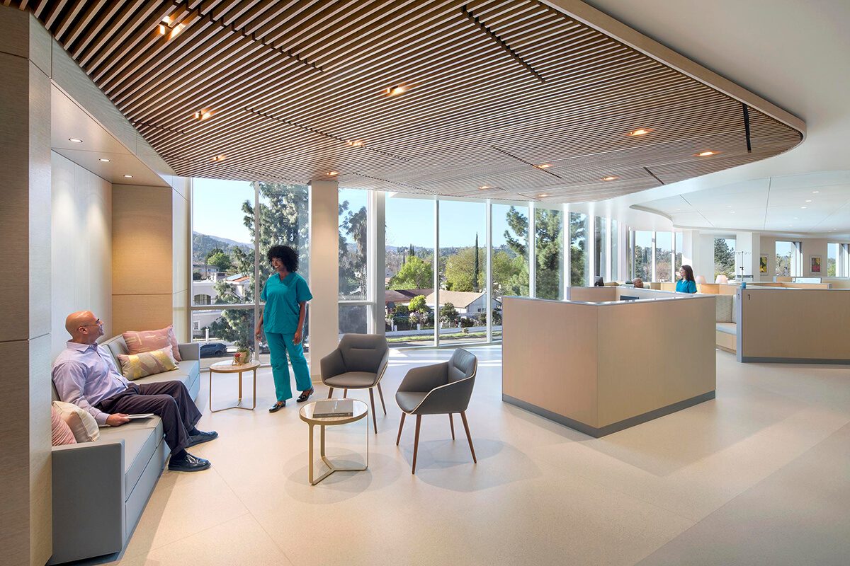 Bright medical facility lounge with wood slat ceiling and floor-to-ceiling windows